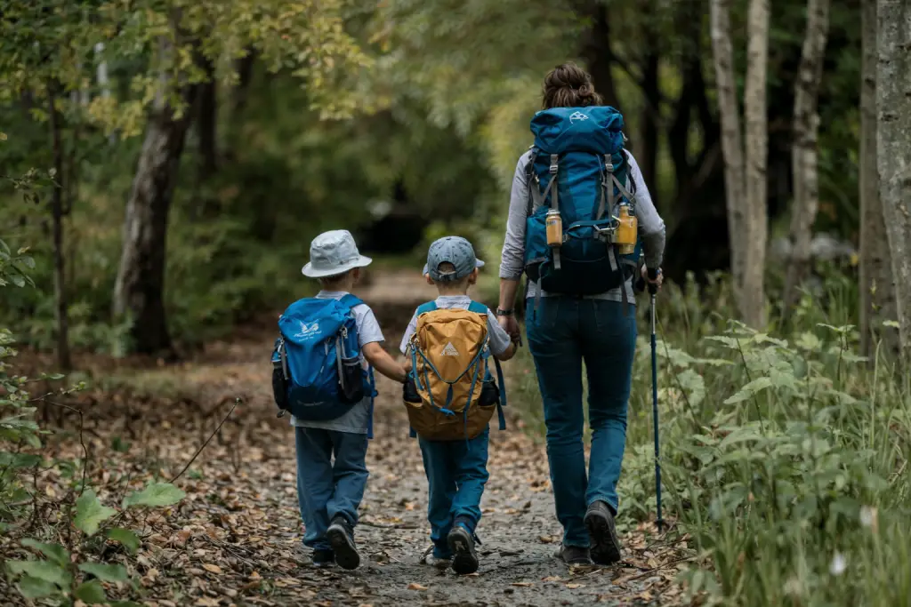 Family hiking on a trail through the woods.